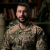 thumb-Rostyslav Pikul in military uniform against the background of bookshelves